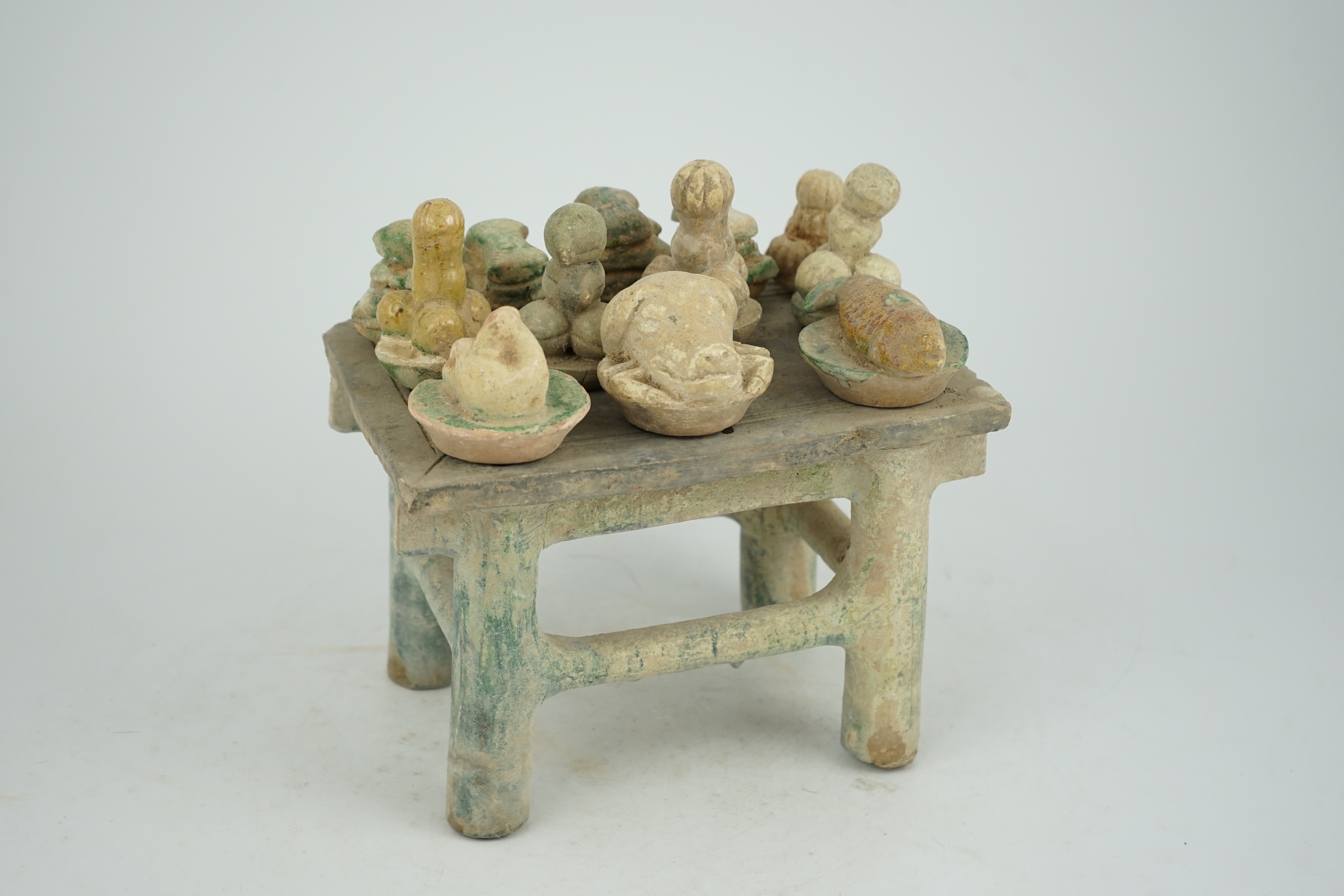 A Chinese glazed pottery altar table with food offerings, Ming Dynasty, c.1550-1600